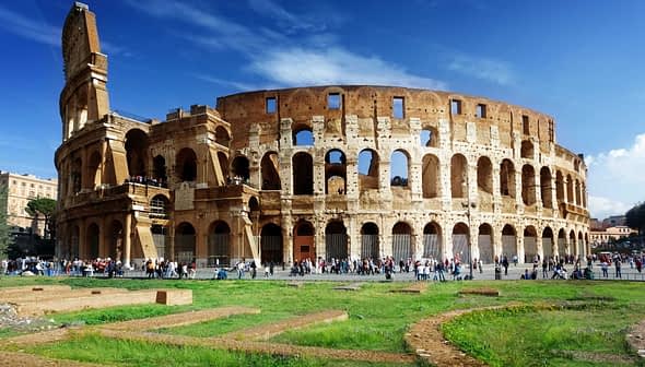 The Colosseum in Rome, an ancient amphitheater with arches and a partially intact structure. - Olive Oil Times