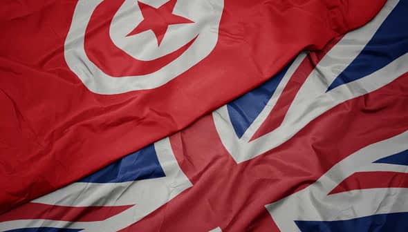 Close-up of the flags of Tunisia and the United Kingdom laid out together. - Olive Oil Times