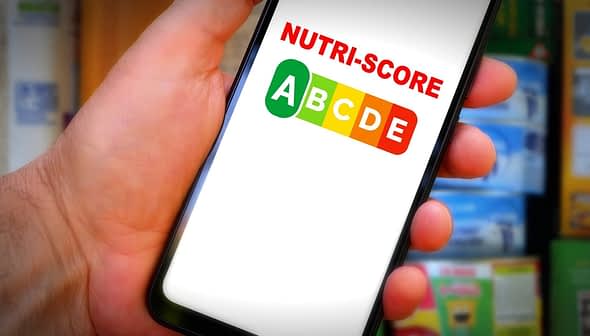 Hand holding a smartphone displaying the Nutri-Score logo with letters A to E in colored boxes. - Olive Oil Times