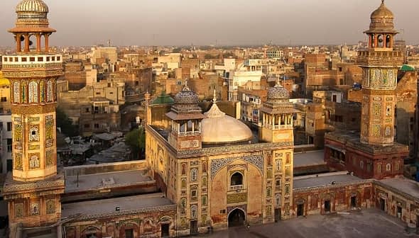 A historic mosque featuring intricate architecture and minarets in an urban landscape. - Olive Oil Times