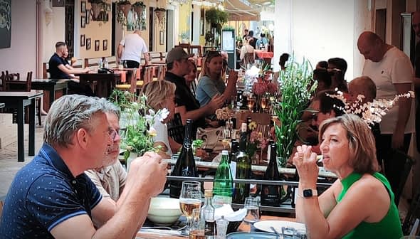 A couple sitting at a table in a restaurant, engaged in conversation while dining. - Olive Oil Times