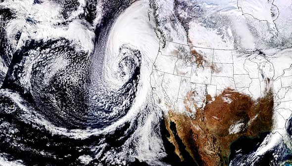 Satellite image showing a weather system swirling off the west coast of North America with cloud formations. - Olive Oil Times