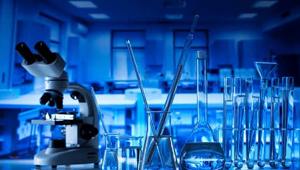 Microscope and various glassware including beakers and test tubes in a laboratory setting. - Olive Oil Times