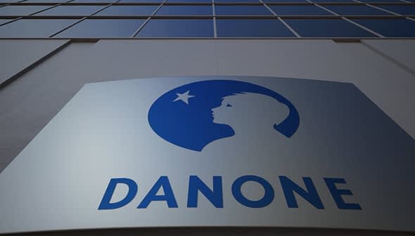 Danone company logo displayed on a building facade with a blue silhouette of a child's profile. - Olive Oil Times