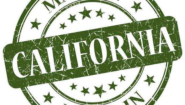 Selo circular verde com o texto "Feito na Califórnia" e estrelas em estilo desgastado. - Olive Oil Times