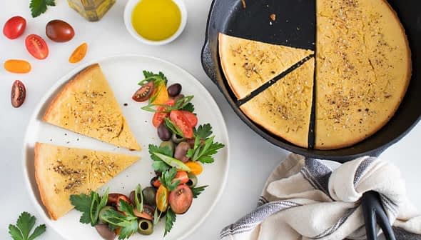 Nohut unundan yapılmış dilimlenmiş pide, domates ve yeşilliklerden oluşan taze salata eşliğinde servis edilir. - Olive Oil Times