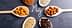 Wooden spoons containing almonds, hazelnuts, sunflower seeds, and cocoa powder arranged around the letter 'Mg' written in chalk. - Olive Oil Times