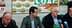 Three men seated at a table during a press conference with COAG branding in the background. - Olive Oil Times