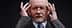 A man with gray hair and glasses holding his head with both hands, appearing deep in thought. - Olive Oil Times