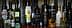 Various bottles of olive oil displayed on a shelf, featuring different brands and designs. - Olive Oil Times
