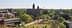 Aerial view of a university campus featuring a historic red brick building and green spaces. - Olive Oil Times