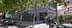A modern office building with glass facade, surrounded by trees and parking spaces. - Olive Oil Times