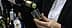 A person pouring olive oil from a bottle into a small glass cup during a tasting event. - Olive Oil Times