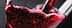 Close-up of red wine being poured into a glass, showcasing bubbles and liquid movement. - Olive Oil Times