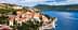 A coastal view of a Mediterranean town with red-roofed buildings and a blue sea. - Olive Oil Times