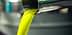 Stream of green olive oil pouring from a metal spout into a container. - Olive Oil Times