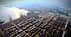 Aerial view of a busy container port with numerous shipping containers stacked. - Olive Oil Times