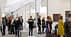 Ljudi prolaze kroz izložbu umjetničke galerije s različitim umjetničkim djelima izloženim na zidovima. - Olive Oil Times