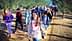 A group of students walking in an olive grove, wearing backpacks and casual clothing. - Olive Oil Times