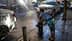 Uma criança de sunga encostada em um hidrante com água jorrando na rua. - Olive Oil Times