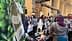 展览会上展示橄榄油产品的展位，背景中有人在互动。 - Olive Oil Times