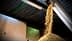 谷物从料斗中倾泻而下，堆放在仓库地面上。 - Olive Oil Times