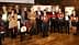 A group of individuals posing with awards during a ceremony, featuring various trophies and certificates. - Olive Oil Times