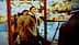 Two men standing in a market with shelves displaying various food items and products. - Olive Oil Times