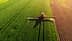 Vista aérea de um pulverizador agrícola aplicando tratamento em um campo verde. - Olive Oil Times