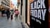 Large sign displaying 'Black Friday' with discount information on a city street. - Olive Oil Times