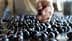 A hand selecting a blueberry from a surface covered with blueberries. - Olive Oil Times