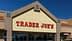 Außenansicht eines Trader Joe's-Geschäfts mit einem auffälligen Schild, auf dem der Geschäftsname steht. – Olive Oil Times