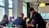 Un giovane uomo serve il cibo a un partecipante seduto durante una presentazione sulle sensazioni olfattive. Olive Oil Times
