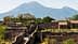 晴れた空の下、ヴェスヴィオ山を背景にポンペイの古代遺跡が見える。 - Olive Oil Times