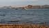 Two sailboats anchored on calm water with mountains visible in the background. - Olive Oil Times