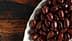 Una vista de cerca de un recipiente lleno de varios tipos de aceitunas, mostrando sus tonos oscuros y claros. Olive Oil Times
