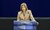 A woman speaking at a podium with the European Parliament logo during a session. - Olive Oil Times