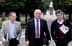 Tres hombres caminando juntos en un parque, llevando maletines y carpetas. - Olive Oil Times