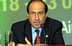 A man in a suit speaking at a podium with a microphone during a conference. - Olive Oil Times