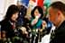 Two women sampling olive oil at a trade show, one holding a tasting cup and the other observing. - Olive Oil Times