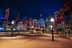 Night view of Sydney cityscape featuring illuminated buildings and decorative flags along a walkway. - Olive Oil Times