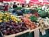 Display of fresh vegetables and fruits including beets, carrots, and lemons at a market stall. - Olive Oil Times