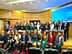 Um grupo de mulheres e homens posando para uma foto em um evento de conferência em um ambiente formal. - Olive Oil Times
