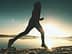 Silhouette einer Person, die bei Sonnenaufgang am Ufer eines Sees entlang joggt. - Olive Oil Times