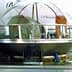 Olive oil mill equipment with a transparent dome showcasing various olive processing materials inside. - Olive Oil Times