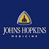 Logo of Johns Hopkins Medicine featuring a blue background with a yellow emblem and text. - Olive Oil Times