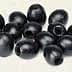 A group of black olives arranged on a light background, showcasing their oval shape and dark color. - Olive Oil Times