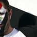 Man with Syrian flag face paint and holding a Syrian flag during a demonstration. - Olive Oil Times