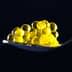 A spoon holding yellow caviar pearls arranged in a clustered formation. - Olive Oil Times