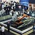 An exhibition booth featuring a robotic arm and various displays with attendees interacting. - Olive Oil Times